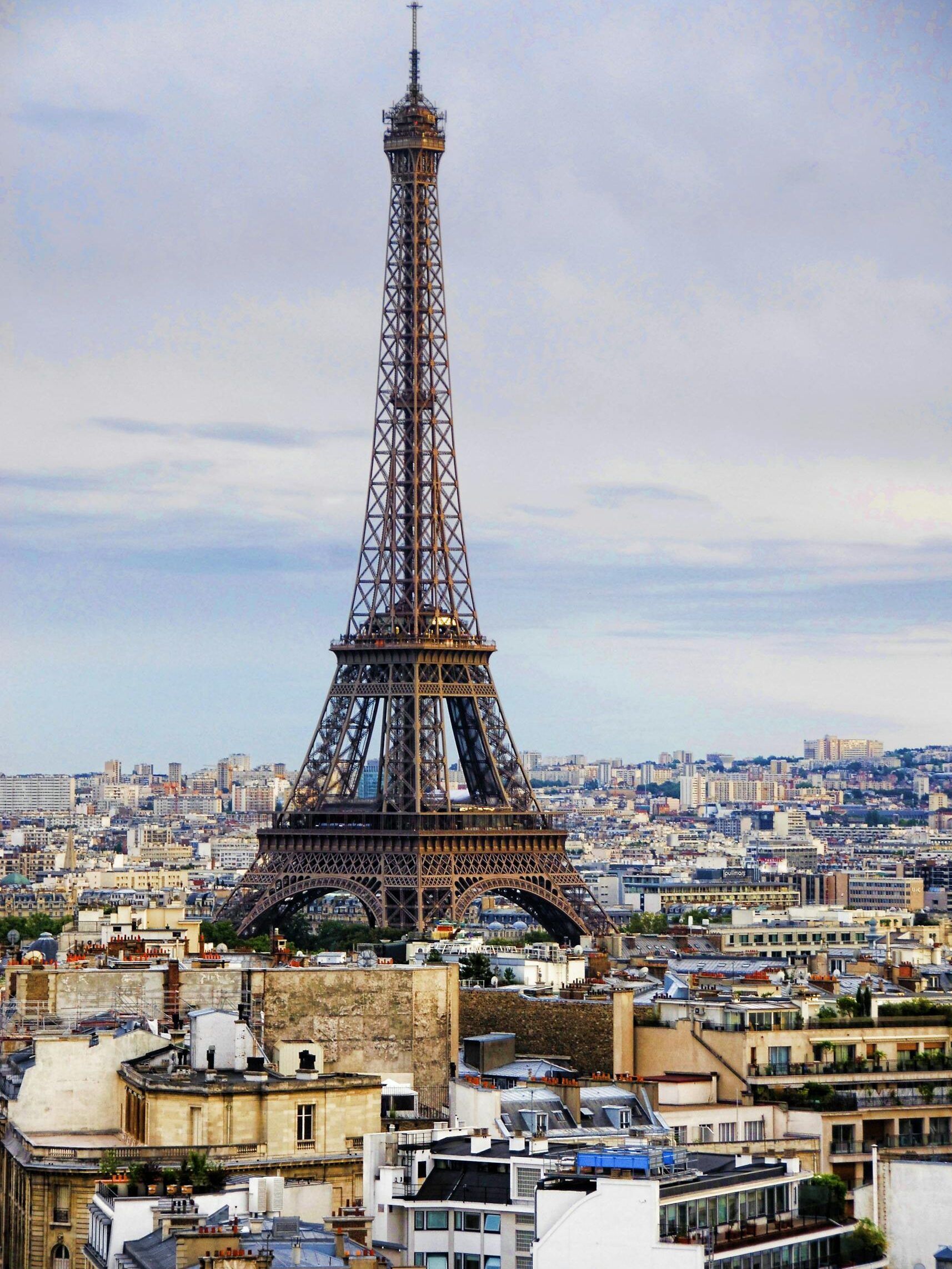 A captivating view of the Eiffel Tower rising above the Paris cityscape under a cloudy sky.